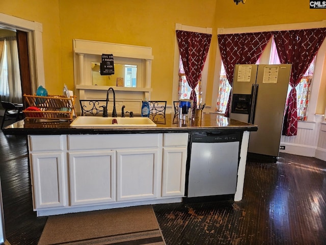 kitchen with dark hardwood / wood-style flooring, sink, stainless steel appliances, and white cabinetry