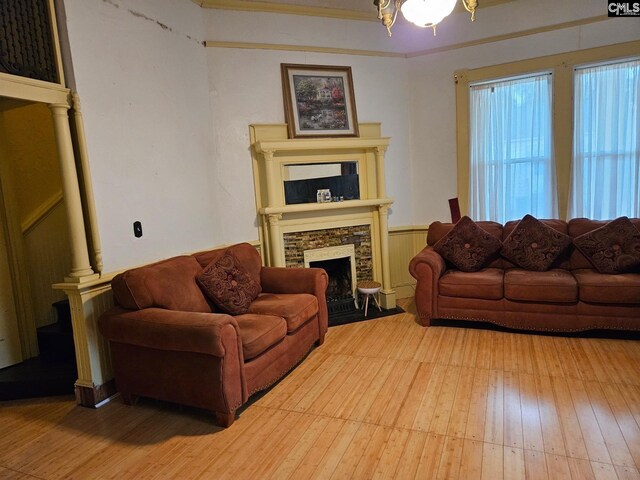 living room with ornamental molding, light hardwood / wood-style flooring, and a fireplace