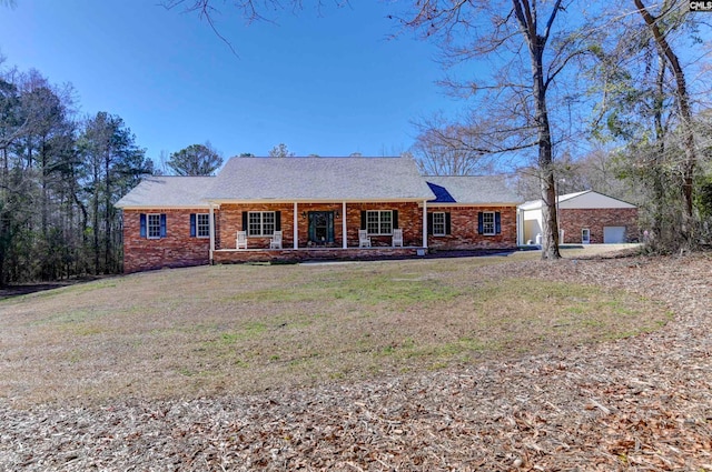 ranch-style house with a front yard and covered porch