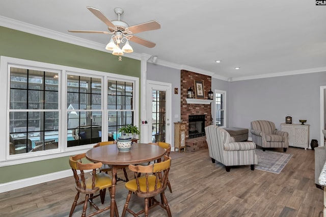 230 Wildlife Rd, Lexington, SC 29072 - dining space with a brick fireplace, brick wall, dark hardwood / wood-style floors, ceiling fan, and ornamental molding
