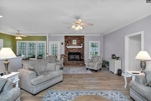 230 Wildlife Rd, Lexington, SC 29072 - living room featuring ceiling fan, brick wall, a brick fireplace, light hardwood / wood-style flooring, and crown molding