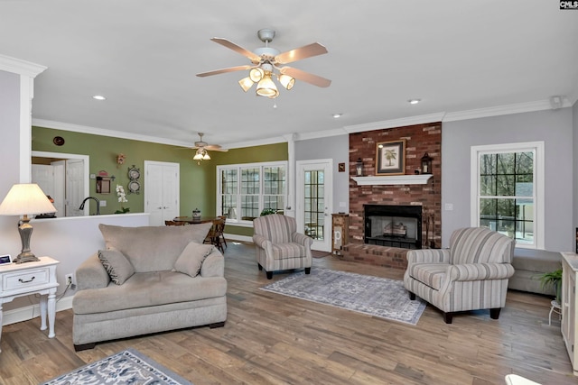 230 Wildlife Rd, Lexington, SC 29072 - living room featuring ceiling fan, brick wall, light hardwood / wood-style floors, a brick fireplace, and crown molding