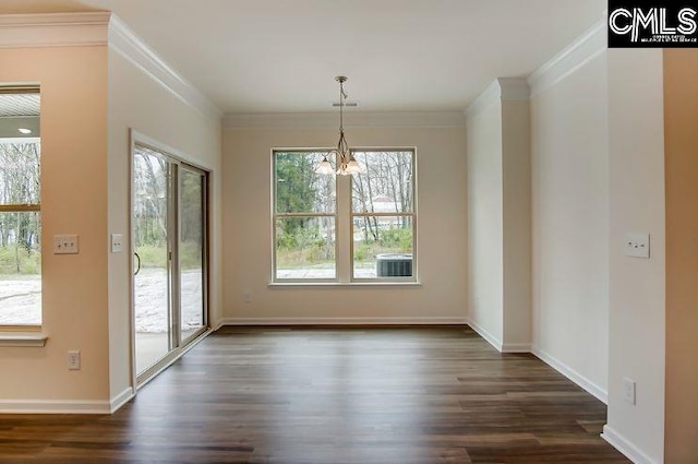 unfurnished dining area featuring dark wood-type flooring, crown molding, and a chandelier