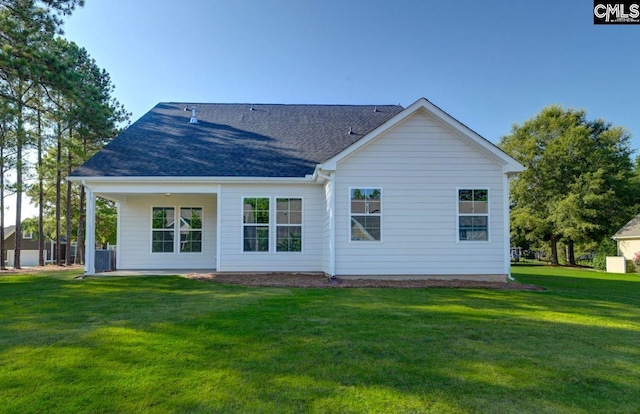 rear view of property featuring a lawn