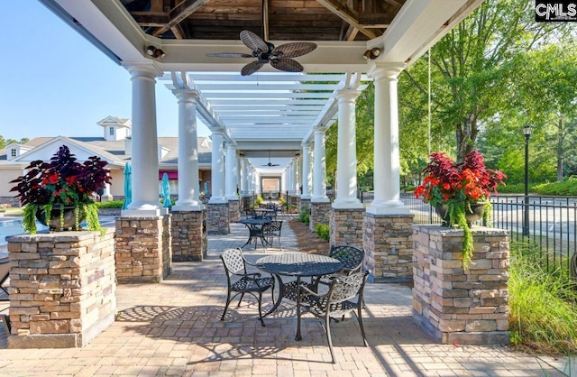 view of patio / terrace with ceiling fan and a pergola