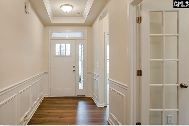 entryway with dark hardwood / wood-style floors, crown molding, and a tray ceiling