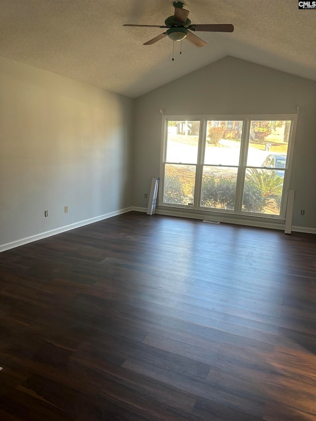 empty room featuring ceiling fan, vaulted ceiling, and dark hardwood / wood-style floors