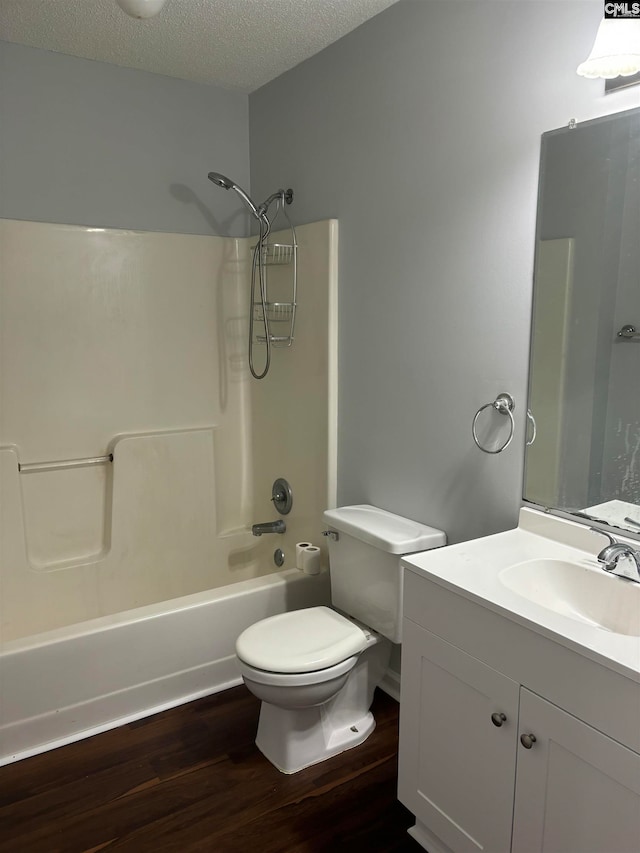 full bathroom featuring hardwood / wood-style floors, toilet, a textured ceiling, and vanity