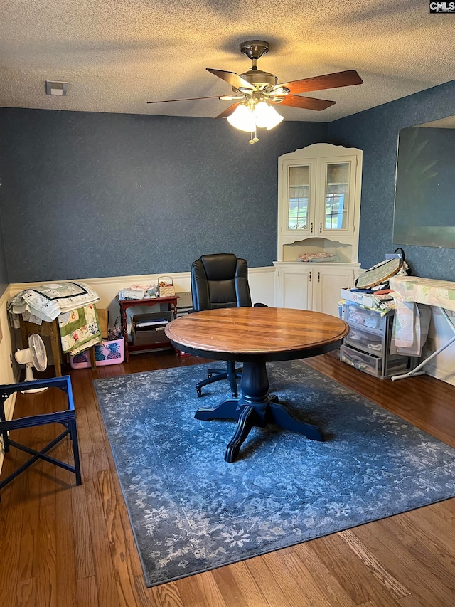 home office with ceiling fan, a textured ceiling, and dark wood-type flooring