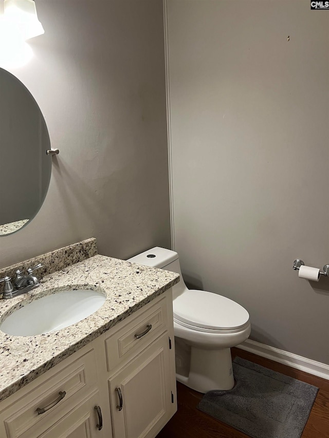 bathroom featuring toilet, hardwood / wood-style floors, and vanity