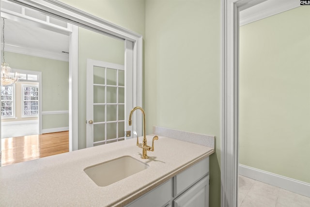 bathroom with crown molding, tile flooring, vanity, and a chandelier