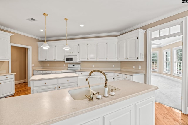 kitchen featuring white appliances, sink, light colored carpet, crown molding, and a center island with sink