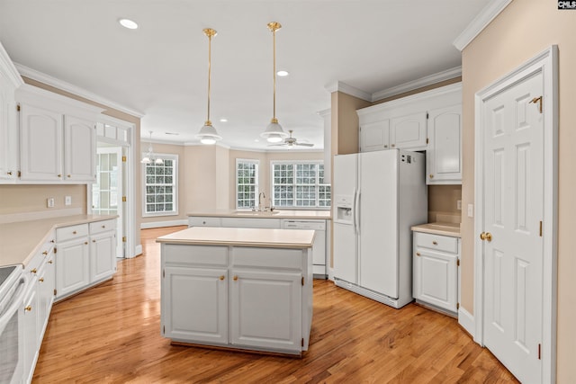 kitchen with white appliances, light wood-type flooring, white cabinetry, and a kitchen island