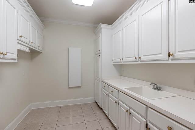 laundry room with crown molding, light tile floors, and sink