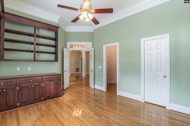 interior space featuring ornamental molding, ceiling fan with notable chandelier, and light wood-type flooring