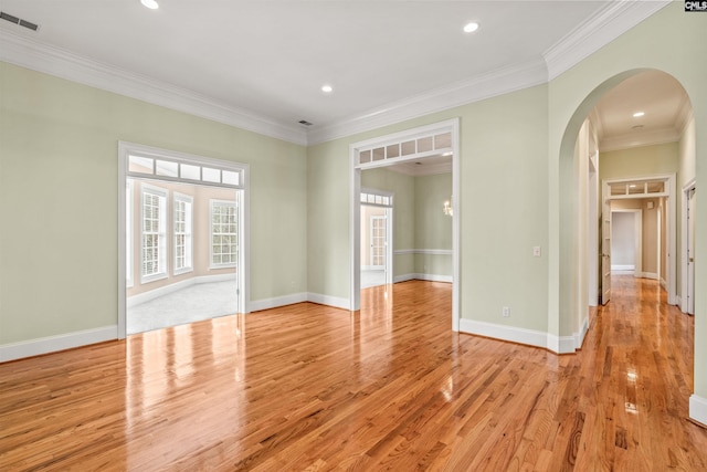 empty room with crown molding and light wood-type flooring