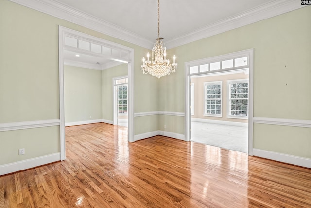 carpeted empty room with a notable chandelier and crown molding