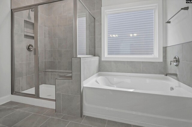 bathroom featuring tile patterned floors, a garden tub, and a shower stall