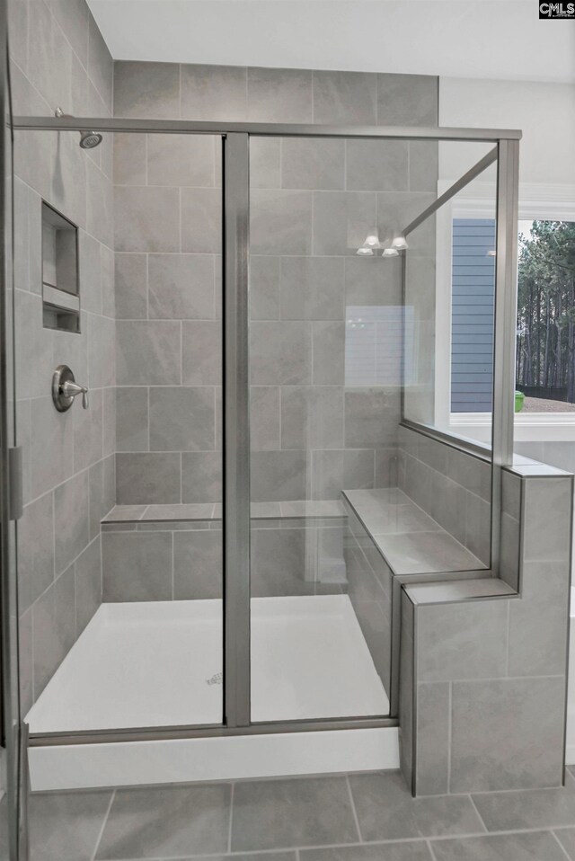 bathroom with tile patterned flooring and a stall shower