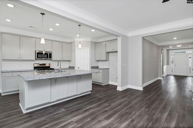 kitchen with dark wood-style floors, baseboards, ornamental molding, stainless steel appliances, and tasteful backsplash