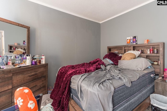 bedroom with a textured ceiling and ornamental molding