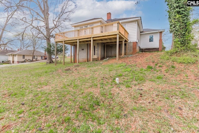 back of property with a wooden deck and a yard