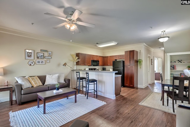 living room with ceiling fan, dark hardwood / wood-style flooring, and ornamental molding