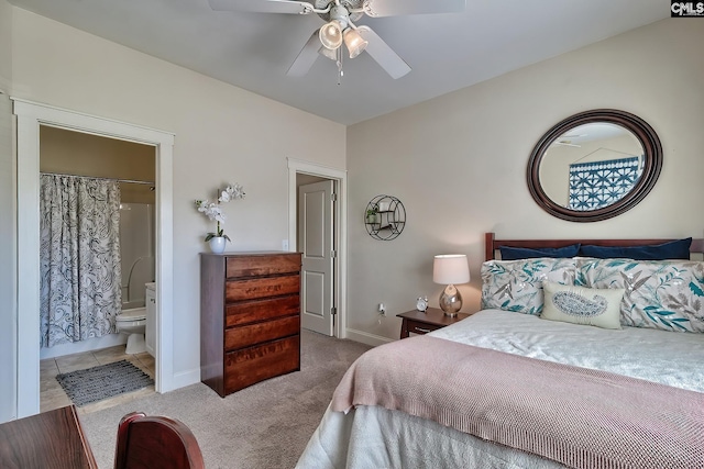 bedroom with light tile flooring, ceiling fan, and ensuite bath