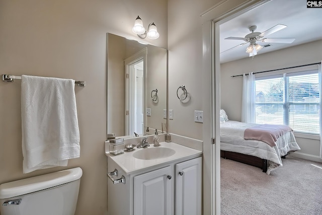 bathroom with toilet, ceiling fan, and vanity