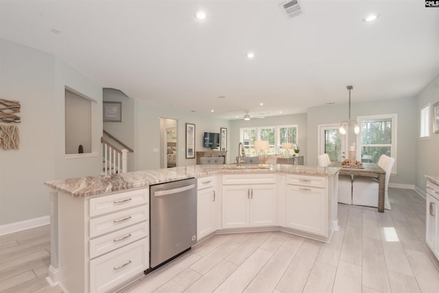 kitchen with pendant lighting, sink, dishwasher, and a kitchen island with sink