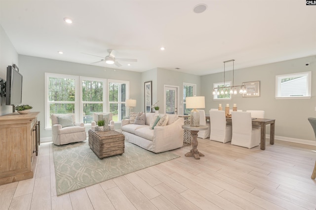 living room featuring ceiling fan, a wealth of natural light, and light hardwood / wood-style floors