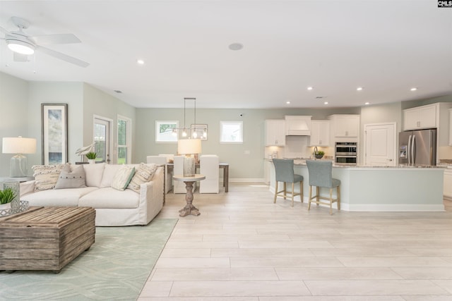 living room featuring light hardwood / wood-style flooring and ceiling fan