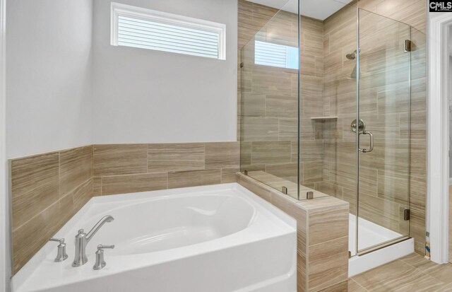 bathroom featuring shower with separate bathtub