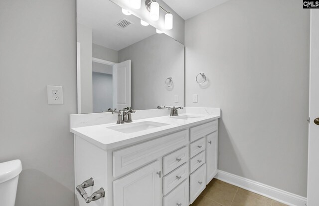 bathroom featuring tile patterned flooring, vanity, and toilet