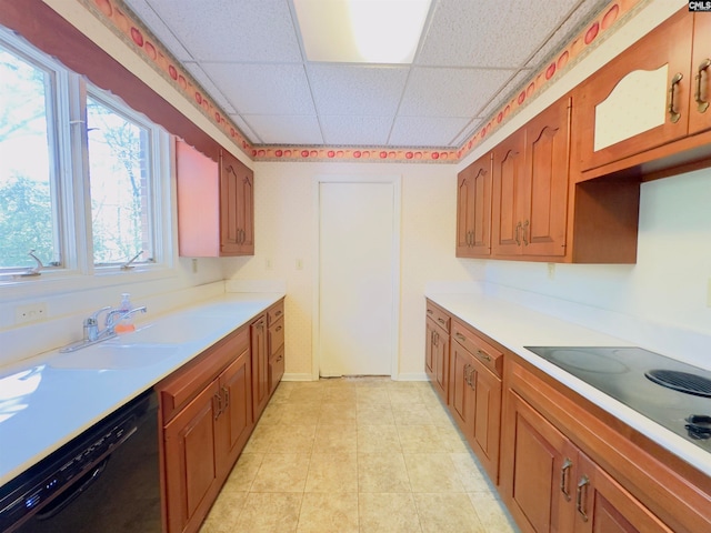 kitchen featuring a paneled ceiling, black appliances, sink, and light tile patterned floors