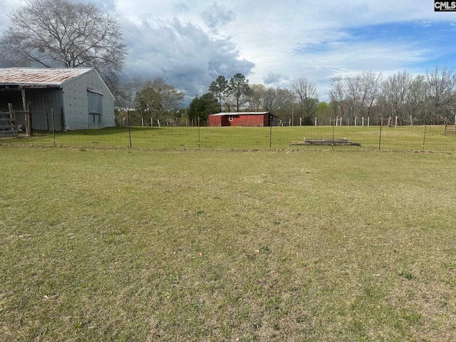 view of yard featuring a rural view and an outbuilding