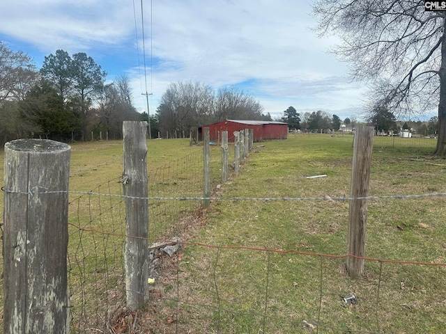 view of yard with an outbuilding and a rural view