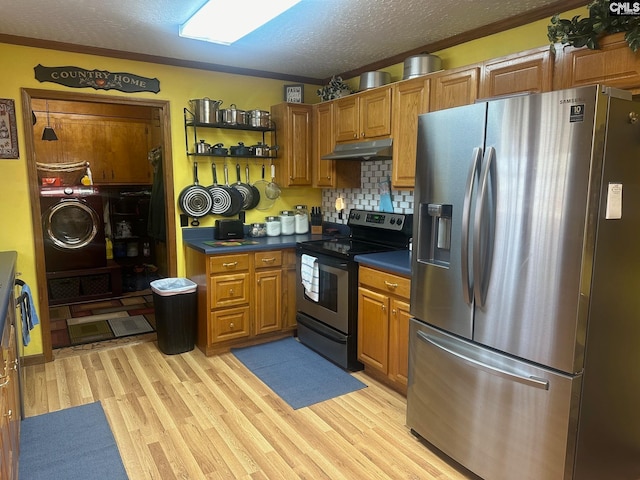 kitchen featuring light hardwood / wood-style flooring, appliances with stainless steel finishes, backsplash, a textured ceiling, and washer / dryer