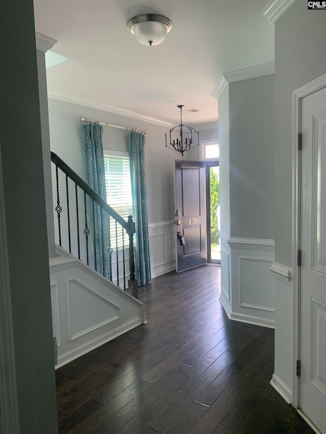 foyer featuring a notable chandelier, crown molding, and dark wood-type flooring