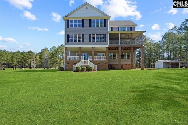 back of house featuring ceiling fan and a yard