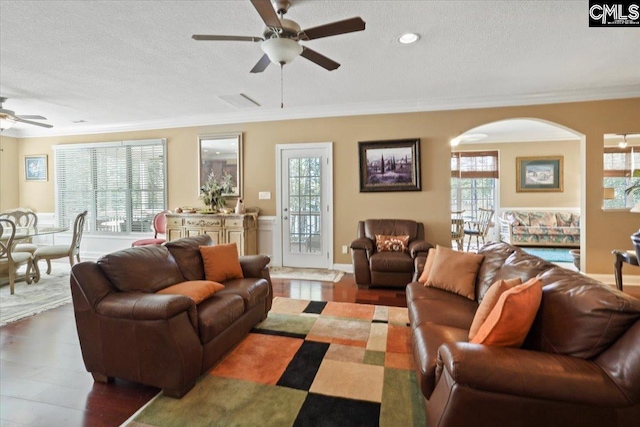 living room featuring ornamental molding, a healthy amount of sunlight, dark hardwood / wood-style floors, and ceiling fan