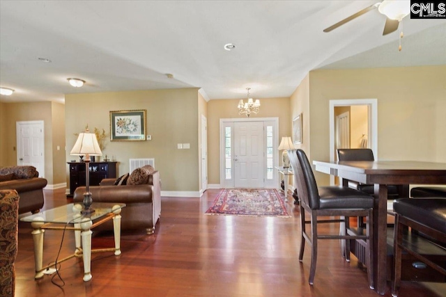 interior space featuring ceiling fan with notable chandelier and dark hardwood / wood-style floors