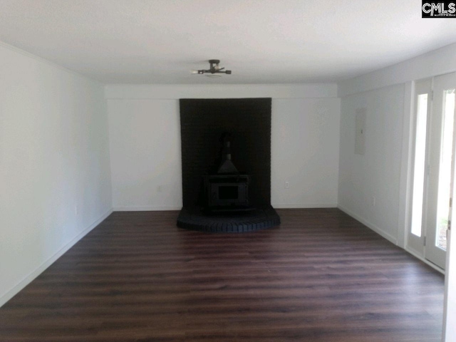 unfurnished living room featuring a wood stove and dark hardwood / wood-style floors