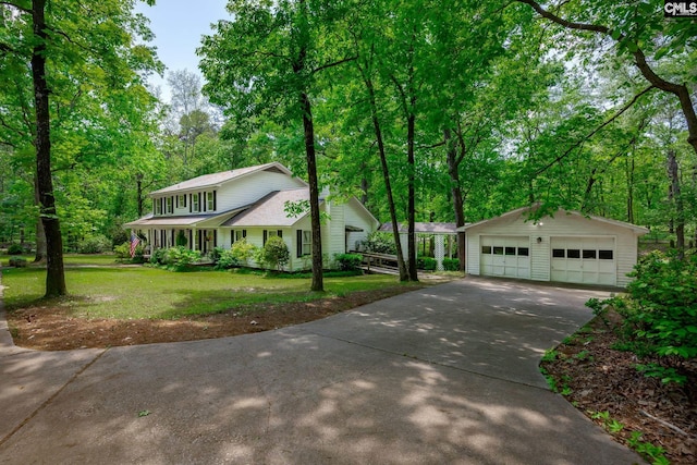 view of front of house featuring a garage, a front yard, and an outdoor structure