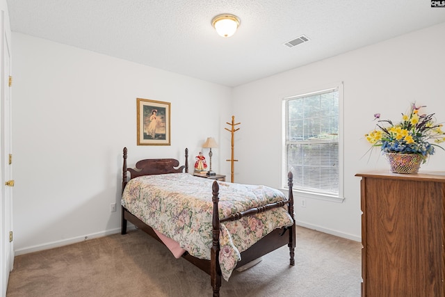 bedroom with carpet floors and a textured ceiling