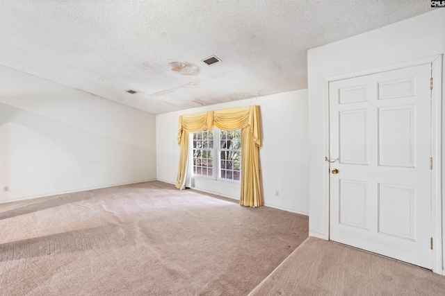 carpeted spare room featuring a textured ceiling