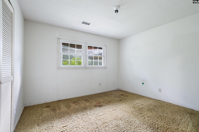 unfurnished bedroom with a textured ceiling and carpet