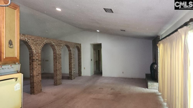 carpeted empty room featuring lofted ceiling