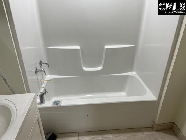 bathroom featuring bathtub / shower combination, vanity, and tile floors