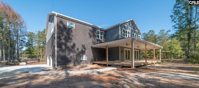 back of house with ceiling fan and a wooden deck